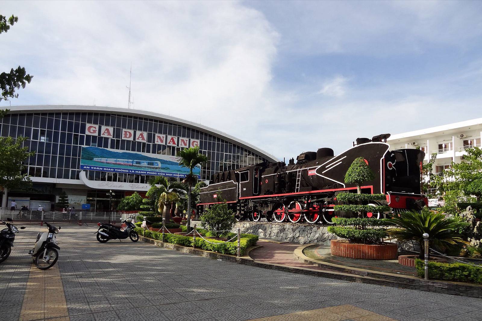 Da Nang Railway Station with a preserved steam locomotive on display in front of the terminal on a sunny day